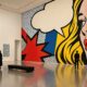 Ilustracija pop-art muzejske retrospektive s točkastim uzorcima i grafičkim oblicima.