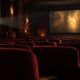 Mračno kino s praznim crvenim sjedalima i svjetlom filmskog projektora